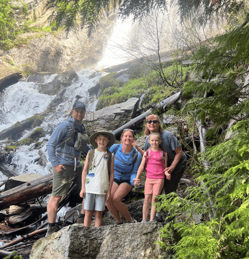 Justin and his family in front of a waterfall